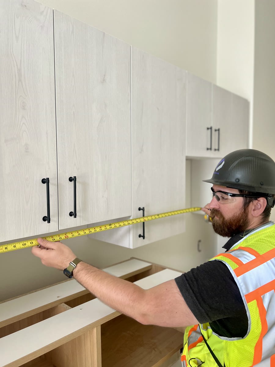 Brad Bronson checking cabinet installation in a finished unit
