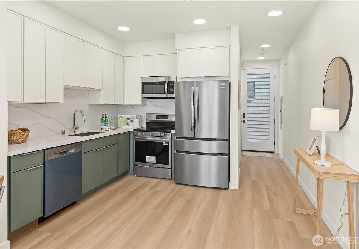 Kitchen with green cabinets and stainless appliances